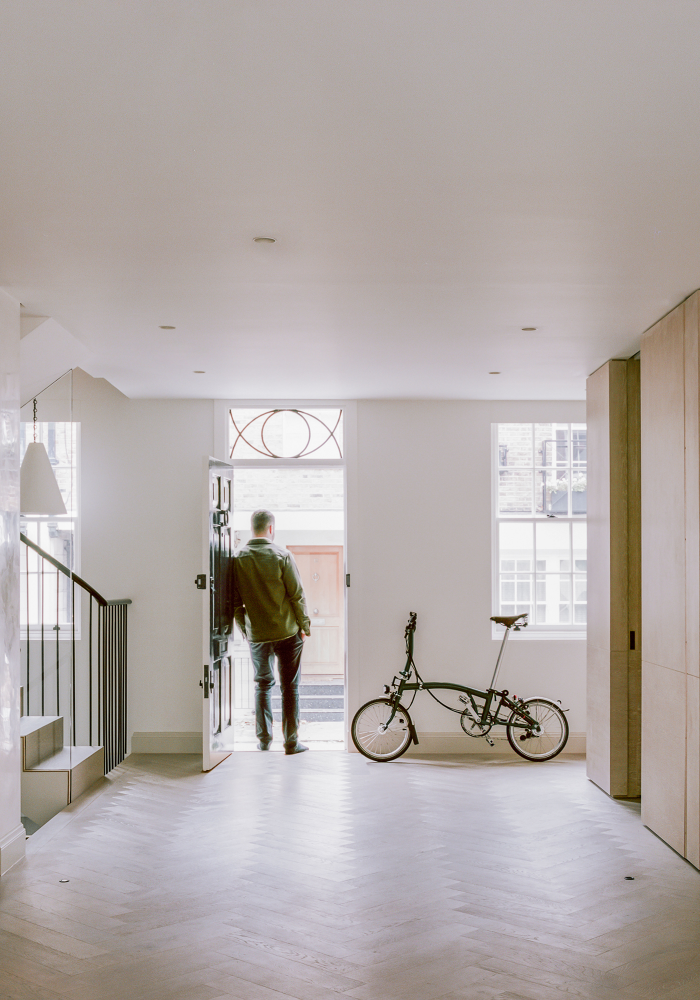 Shows a person standing in a bright and airy room in the renovated Mew House